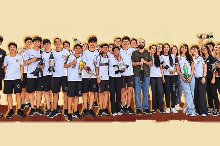 Turma do Ensino Médio do Colégio Carmo com os foguetes de garrafa PET construídos para a OBAFOG, ao lado do professor